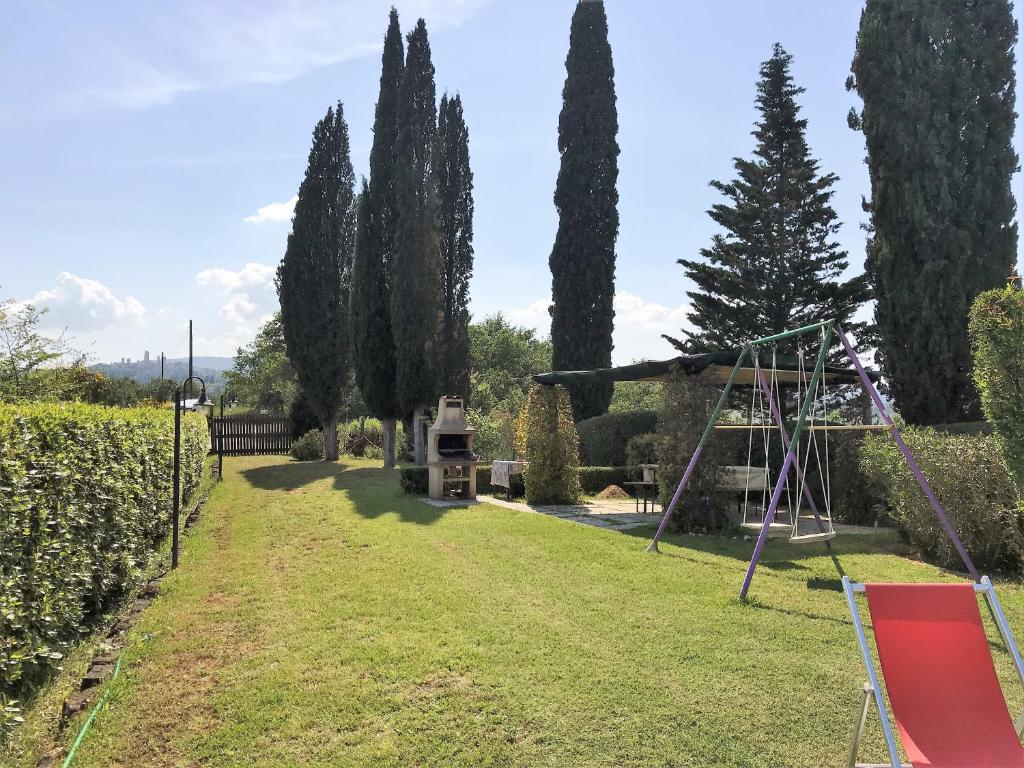 a playground in a garden with trees and a swing at Podere Remignoli in San Gimignano