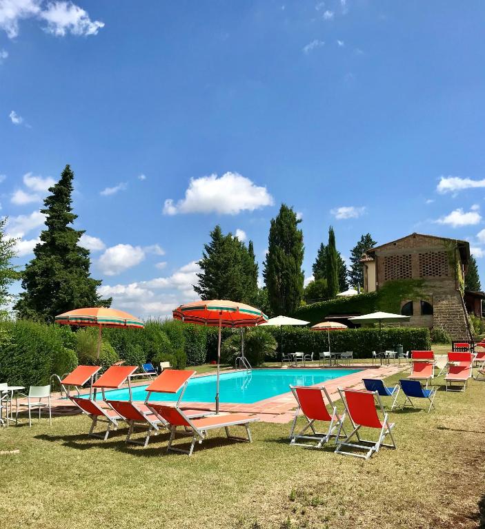 a group of chairs and umbrellas next to a pool at Podere Remignoli in San Gimignano