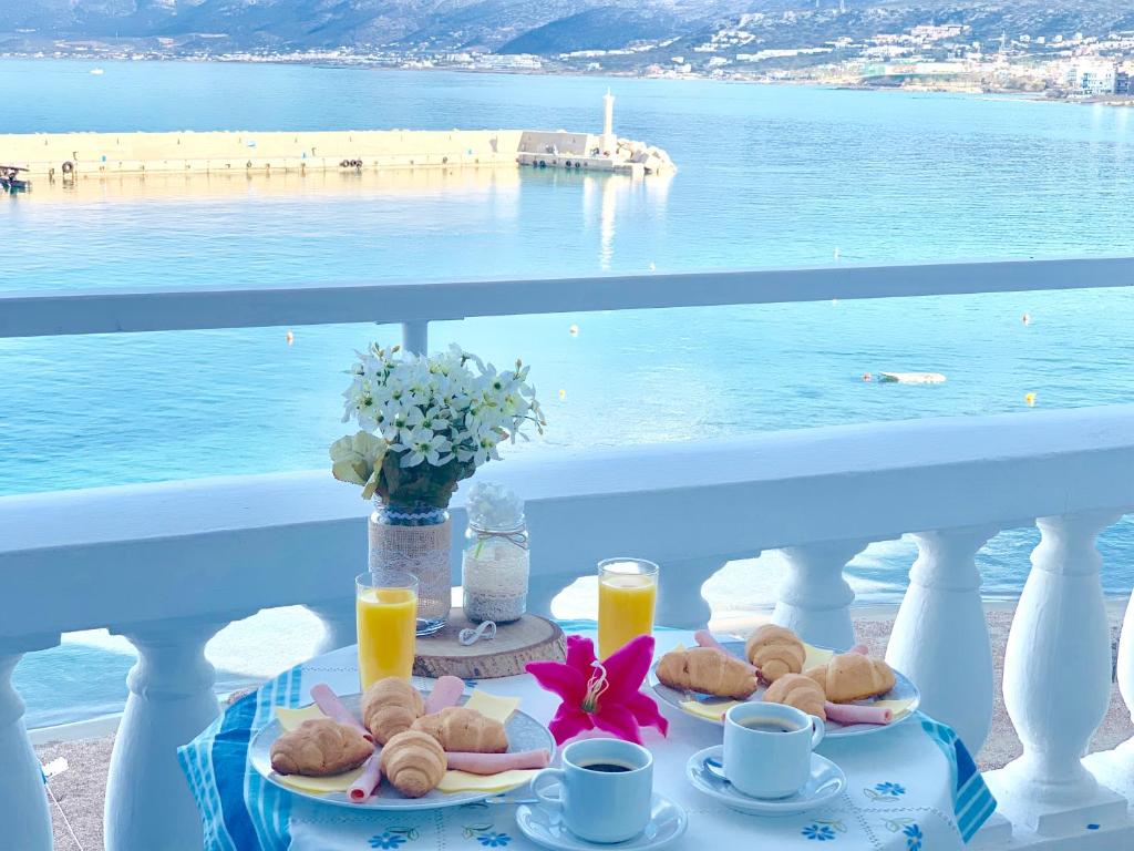a table with food on a balcony with a view of the ocean at The Blue Apartments in Hersonissos