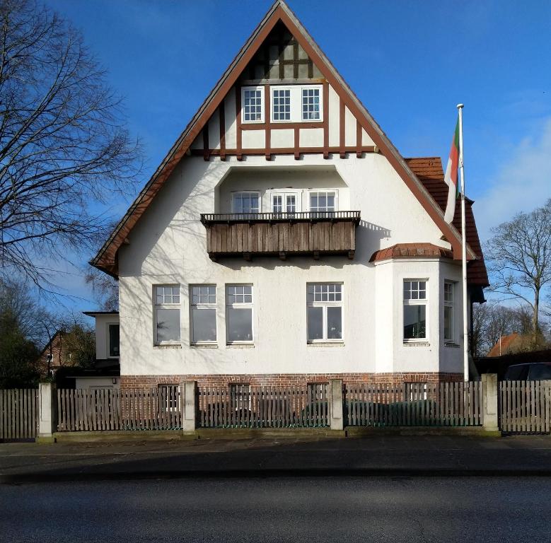 ein weißes Haus mit einem Gameradach in der Unterkunft Villa Kruckau in Eckernförde