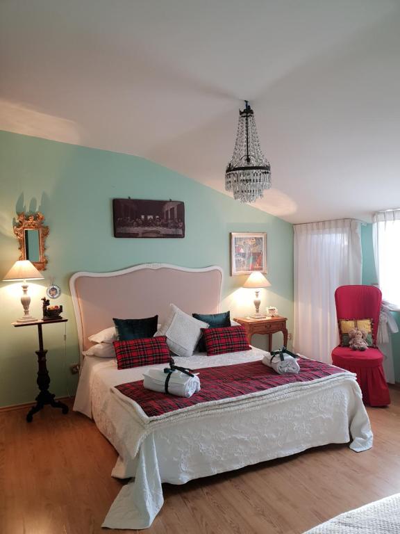 a bedroom with a large white bed with two chairs at Hotel Lieto Soggiorno in Assisi