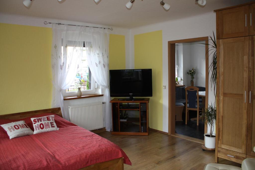 uma sala de estar com uma cama e uma televisão de ecrã plano em Ferienwohnung Scharnhorst em Dresden