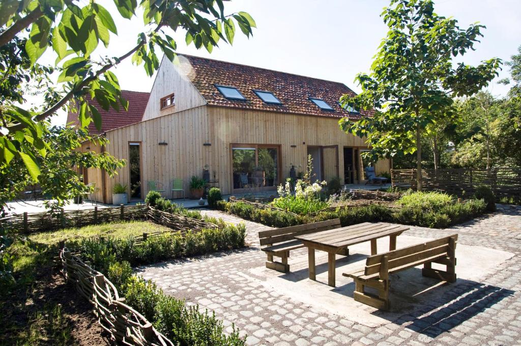 een houten huis met een picknicktafel ervoor bij De kiezel in Hasselt