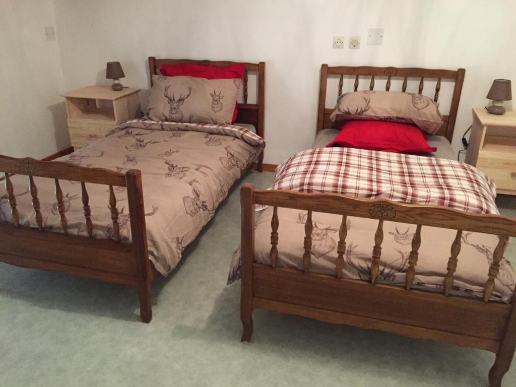 2 camas individuales en una habitación con 2 mesas en Chouetterie en Saint-Dizier-Leyrenne