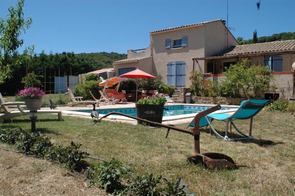 a yard with a swimming pool and a house at Le Termenès in Félines-Termenès