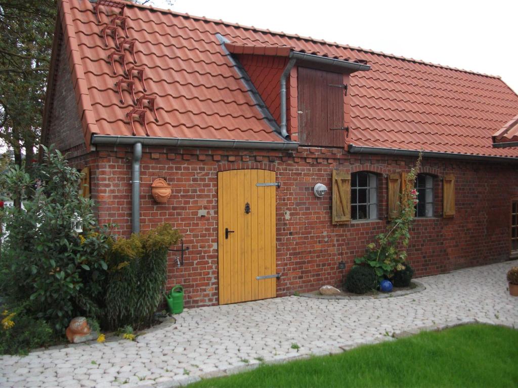 una casa in mattoni rossi con una porta gialla di Ferienhaus Vörn-Diek a Hohnstorf