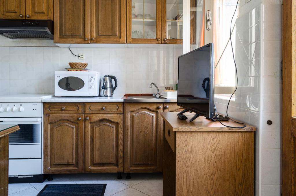 a kitchen with wooden cabinets and a television on a counter at Apartmani Marko in Makarska