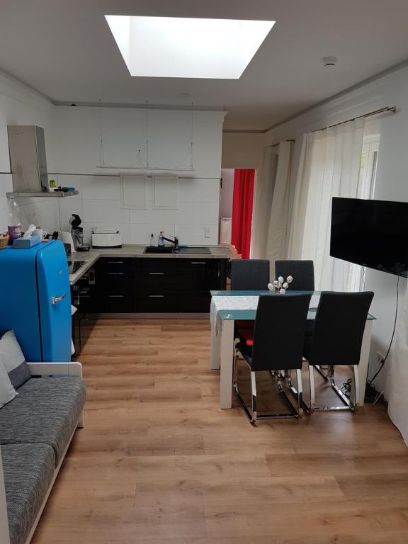 a living room with a table and chairs and a kitchen at 2 Raum Gartenwohnung am Spreewaldradweg in Cottbus in Cottbus