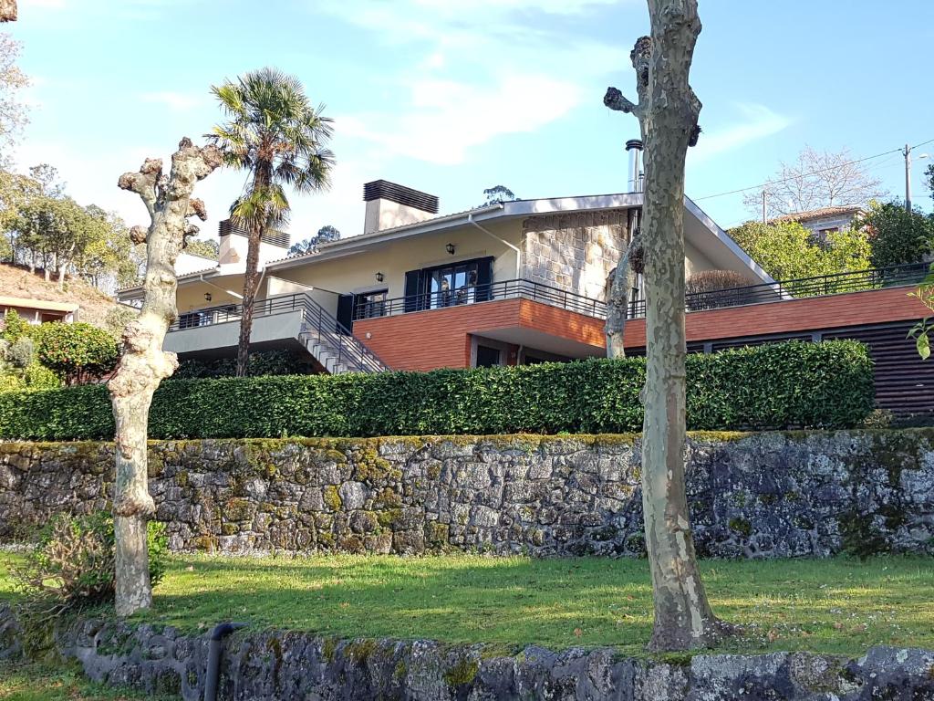 una casa con una pared de piedra y árboles en Vivenda do Paúl, en Gerês