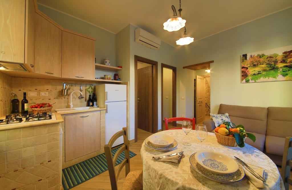 Casa Vacanze La Portella في فوندي: مطبخ وغرفة طعام مع طاولة في الغرفة
