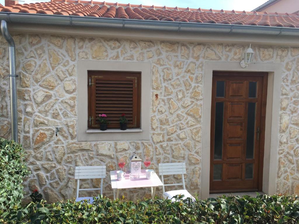 een huis met een tafel en twee stoelen en een raam bij Croatian Home Apartments in Zadar