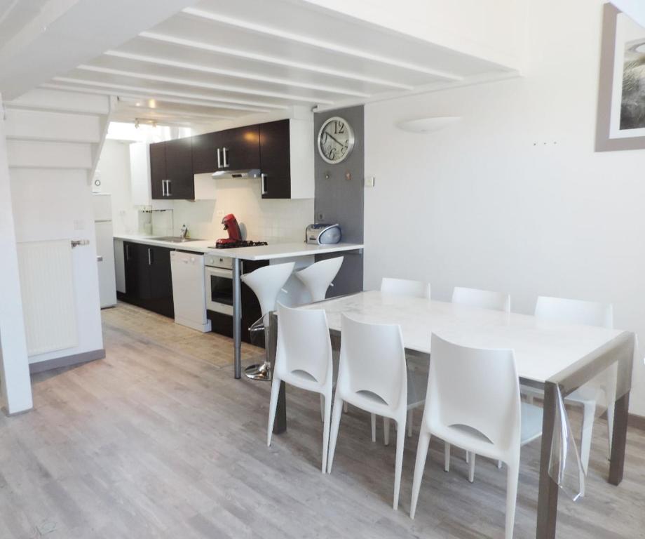 uma cozinha e sala de jantar com uma mesa branca e cadeiras em Le Metz, Duplex, 2 Chambres em Le Touquet-Paris-Plage