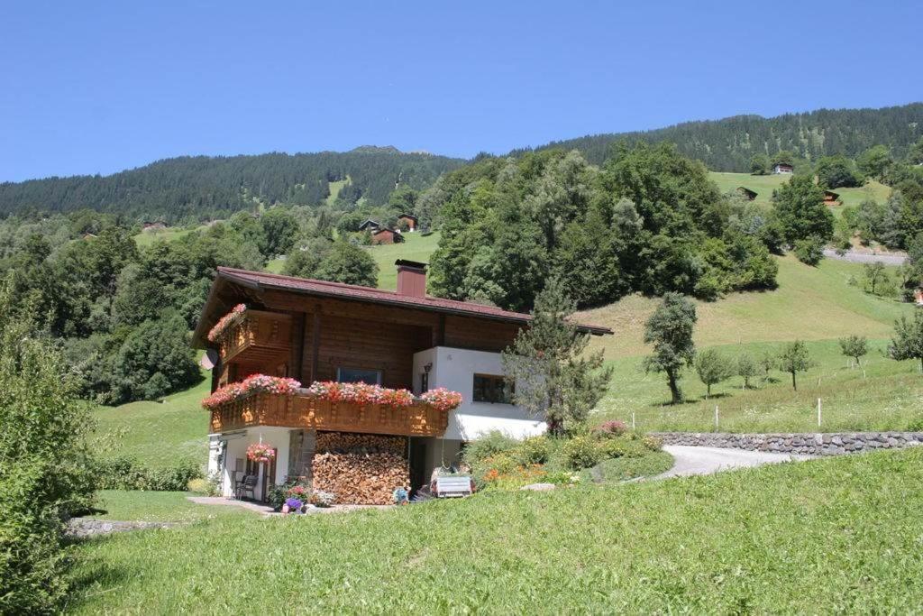 Una casa en una colina con flores. en Ferienwohnung Rudigier Elke, en Silbertal