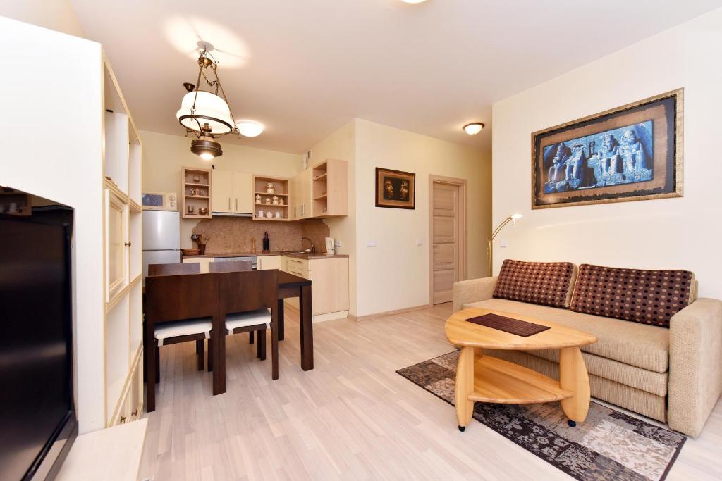 a living room with a couch and a table at Apartamentai Berzas in Palanga