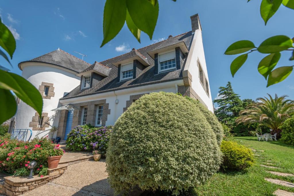 een huis met een grote struik ervoor bij Villa des Fleurs d'Ajoncs in Concarneau