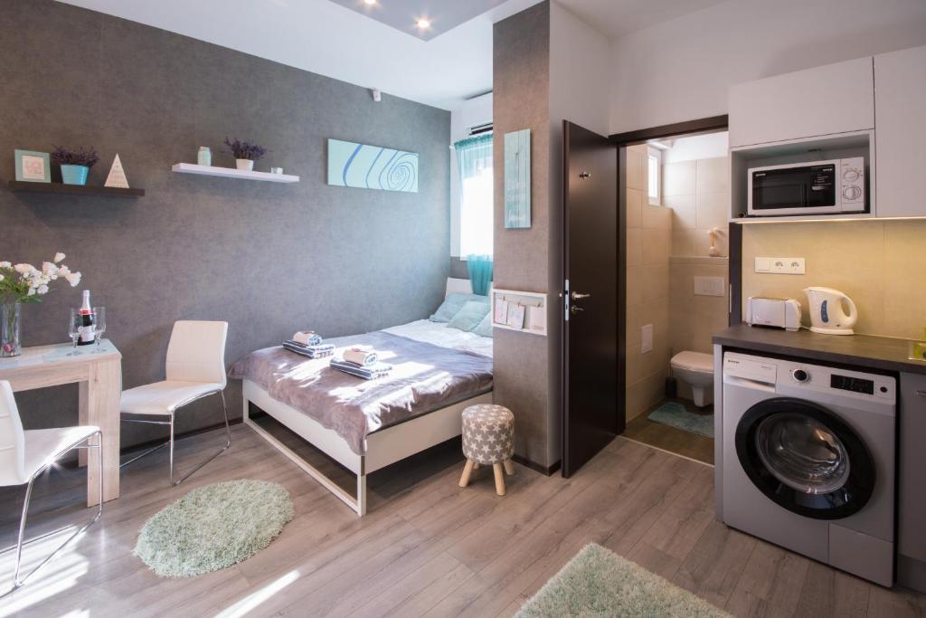 Habitación pequeña con cama y lavadora. en Petra's Tranquil Nest in Downtown Budapest, en Budapest