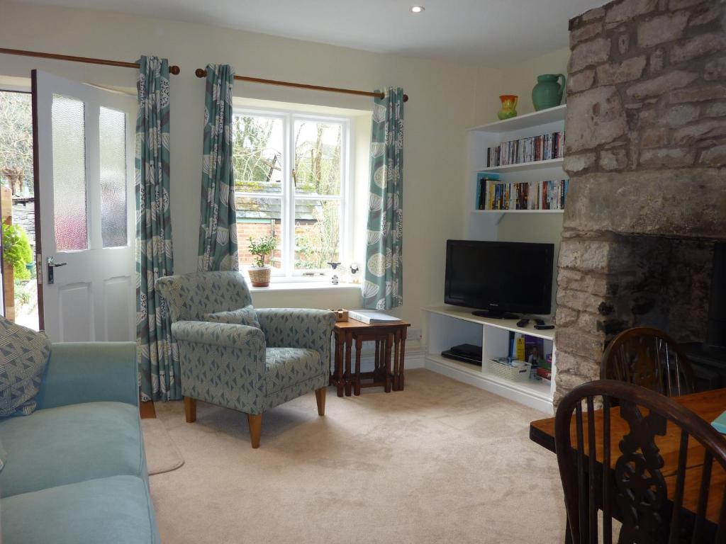 a living room with a fireplace and a tv at No 10 Dulas in Hay-on-Wye