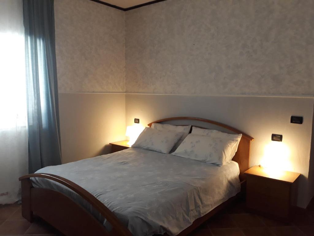 a bedroom with a large bed with two lamps on it at B&B Angel's in Canosa Sannita
