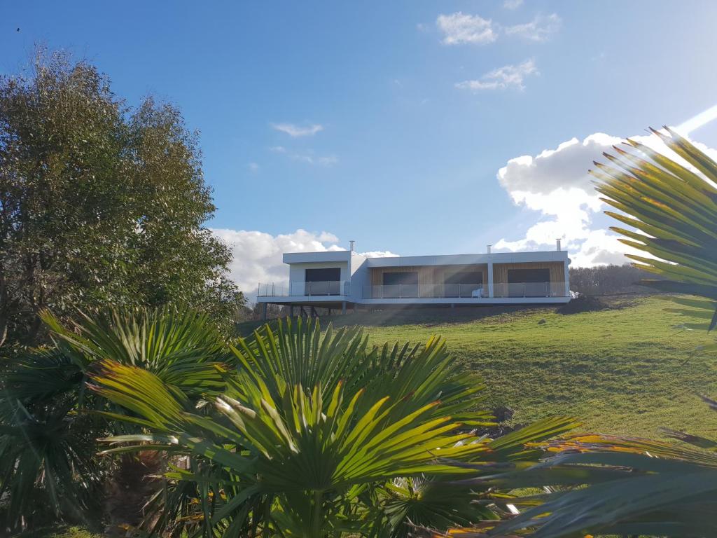 a house on top of a hill with palm trees at Les Gîtes du Cap Cod in Varengeville-sur-Mer