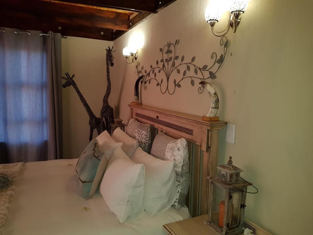 Schlafzimmer mit einem Bett mit einem Giraffenkopf in der Unterkunft Lodge Twentyfour Mabalingwe Nature Reserve in Bela-Bela