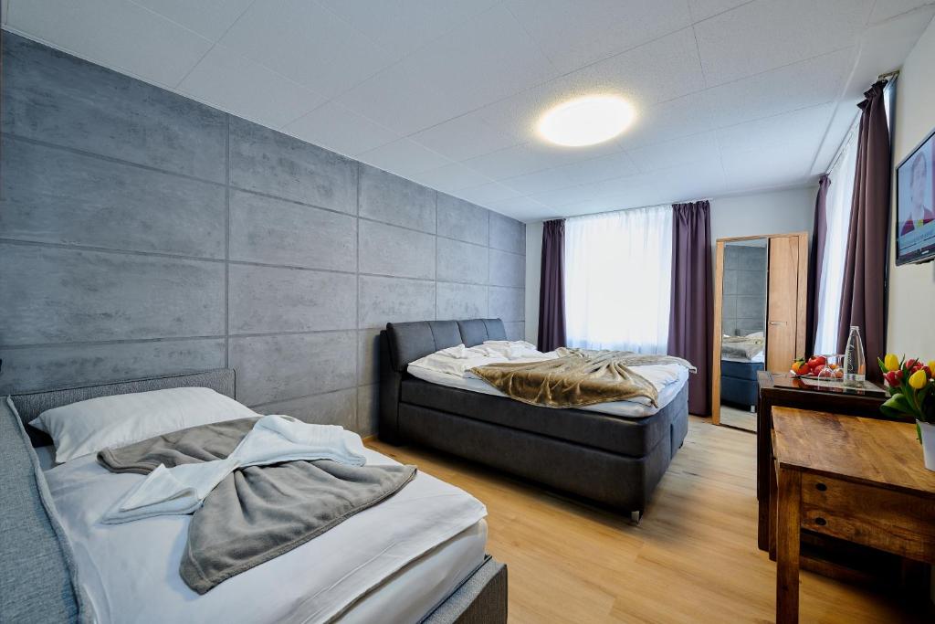 a hotel room with two beds and a desk at Hotel Giamas in Straubing