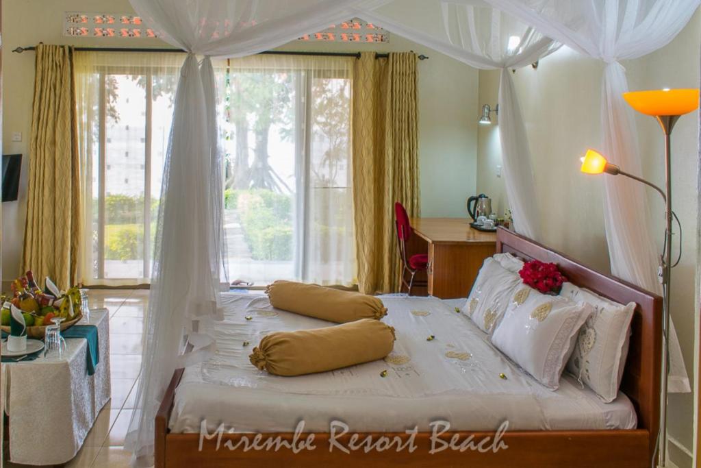 Kalangala的住宿－Mirembe Resort Beach Hotel Ssese，一间卧室配有一张白色天蓬床