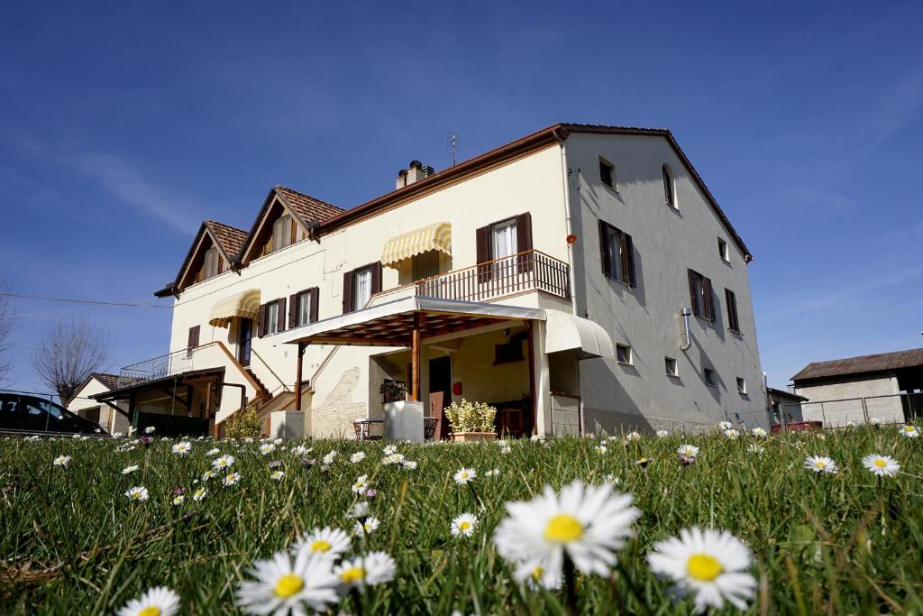 un bâtiment avec un champ de fleurs devant lui dans l'établissement A casa di Stella, à Vaccarile