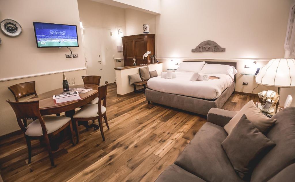 ein Hotelzimmer mit einem Bett, einem Tisch und einem Sofa in der Unterkunft Acacia Firenze -Timo in Florenz