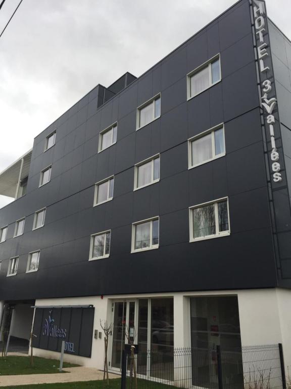 a black building with a sign that reads my business at HOTEL LES 3 VALLÉES in Saran