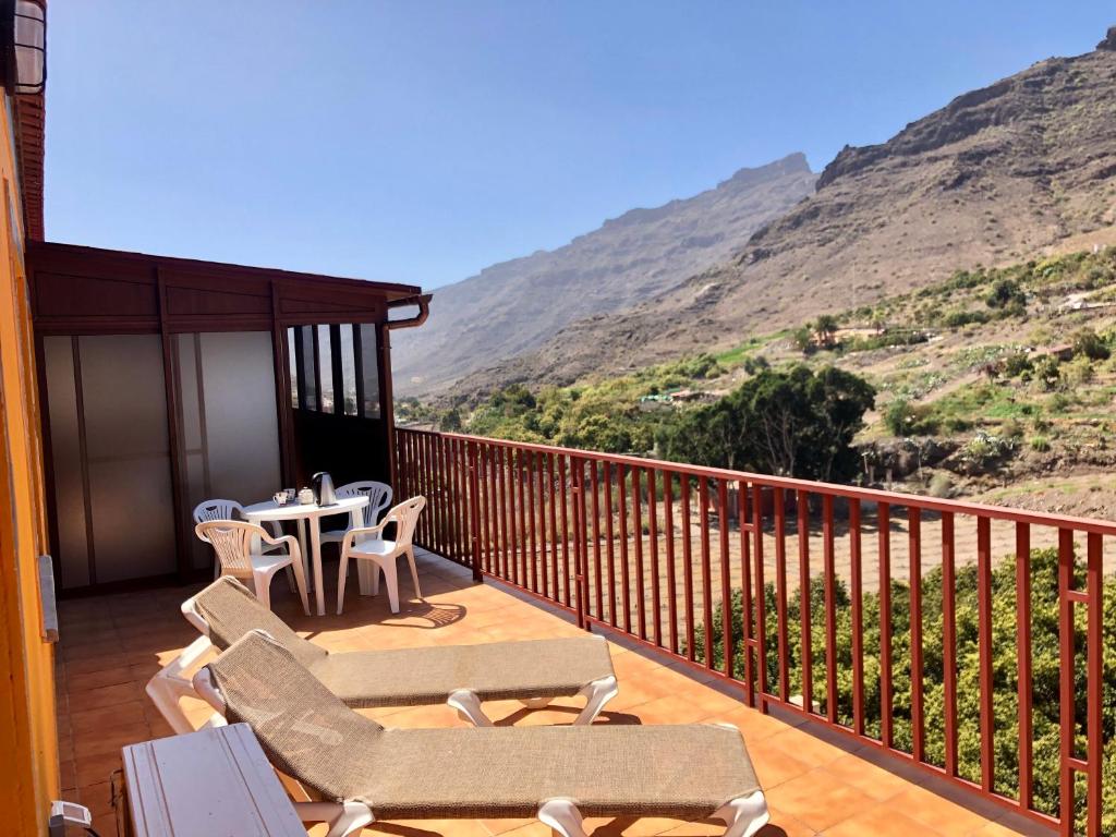 a balcony with chairs and a table with a view at Apartamento Las Tejas Mogán in Mogán