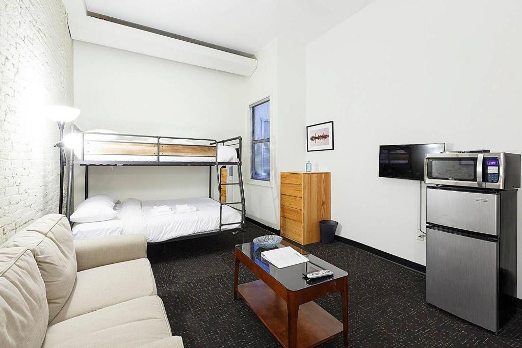 Temple Place Suites 2+3 في بوسطن: غرفة معيشة مع أريكة وسرير بطابقين