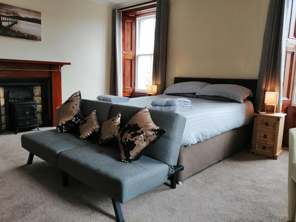 1 dormitorio con 1 cama y 1 sofá en Thorshaven Apartment, Orkney, en St Margaret's Hope
