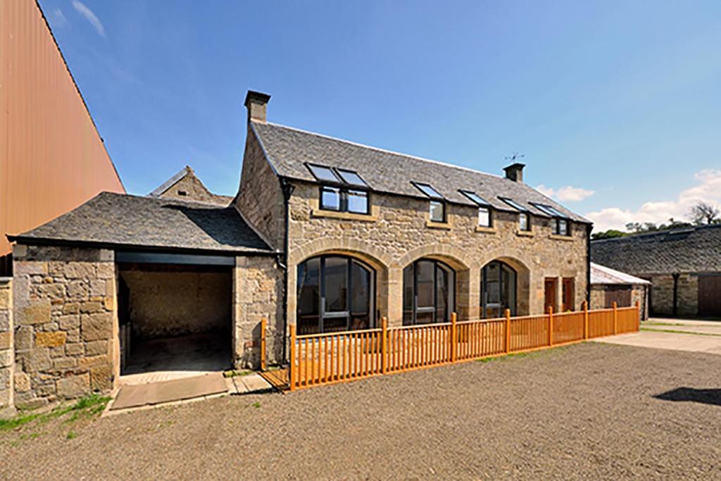 uma grande casa de tijolos com uma cerca em frente em The Arches, Borthwick Mains Farm, em Gorebridge