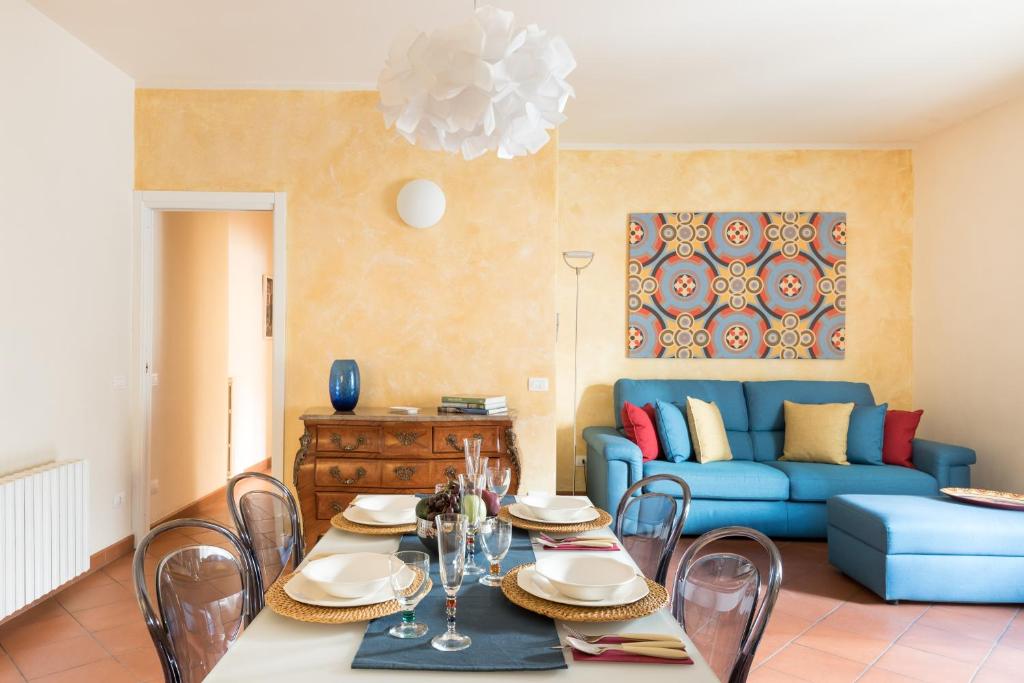 - un salon avec une table et un canapé bleu dans l'établissement Design Apartments Florence- Florence City Center, à Florence