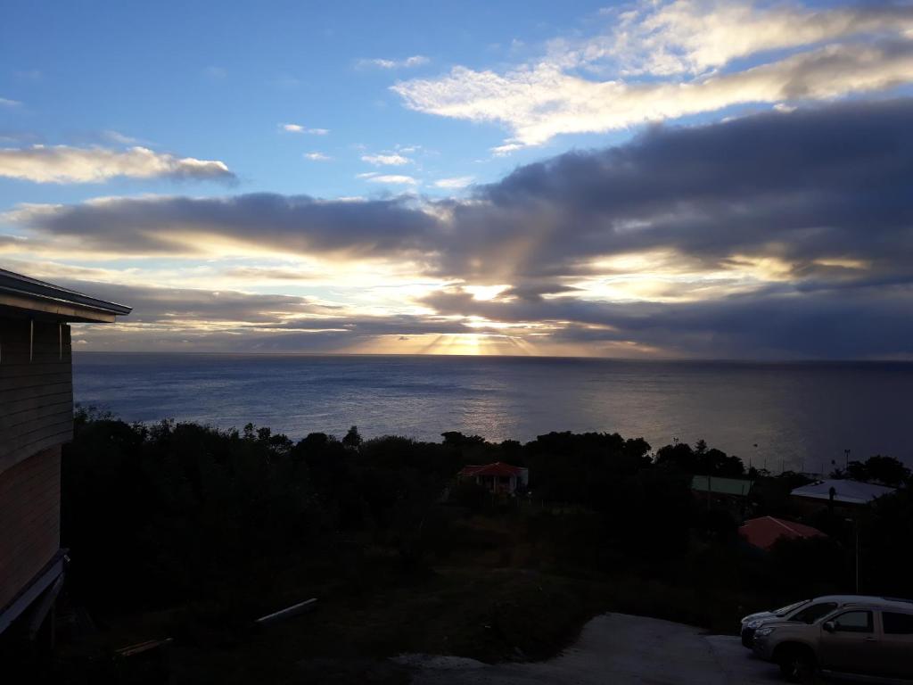 a sunset over the ocean under a cloudy sky at bel ti kay in Les Anses-dʼArlets