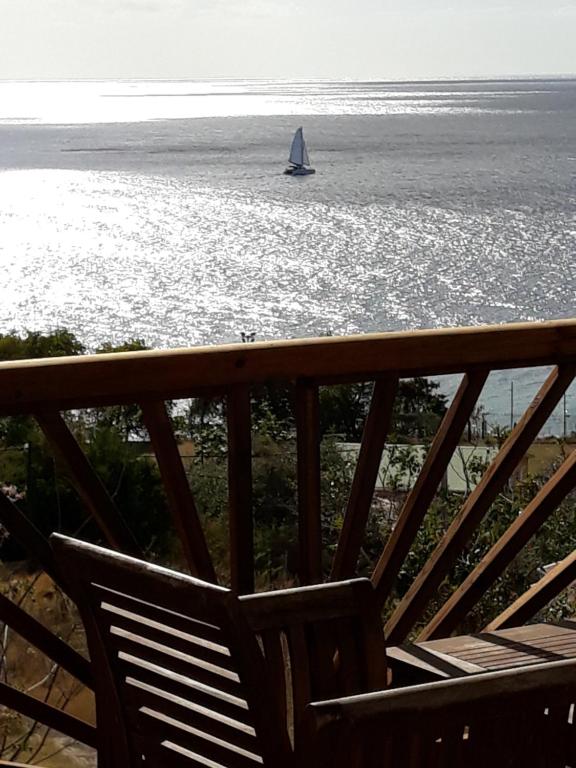 a sail boat in the water with a chair at bel ti kay in Les Anses-dʼArlets