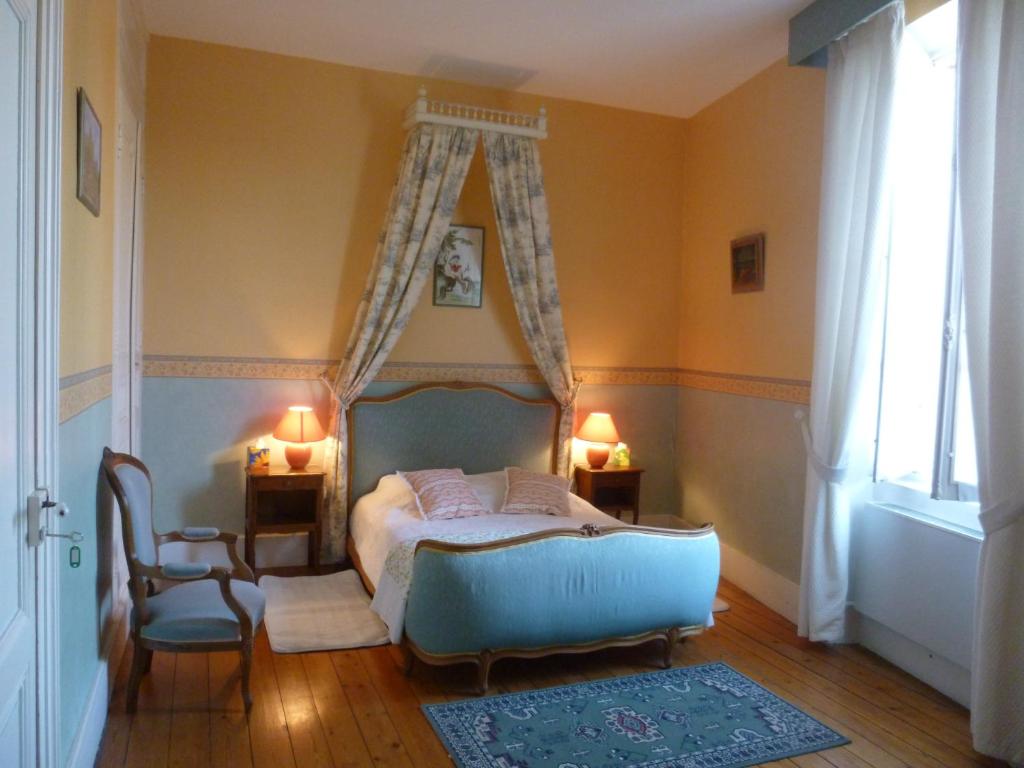 1 dormitorio con 1 cama, 1 silla y 1 ventana en Clos Muneau, en Aiguillon