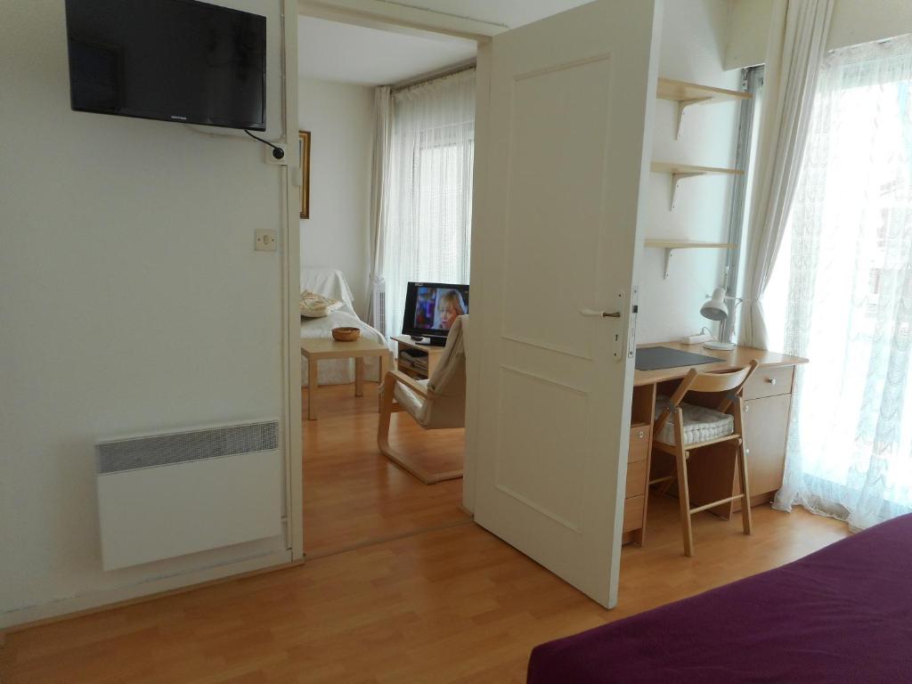 a room with a bed and a desk with a computer at T2 Bassin d'Arcachon, 200m plage, centre-ville in Andernos-les-Bains