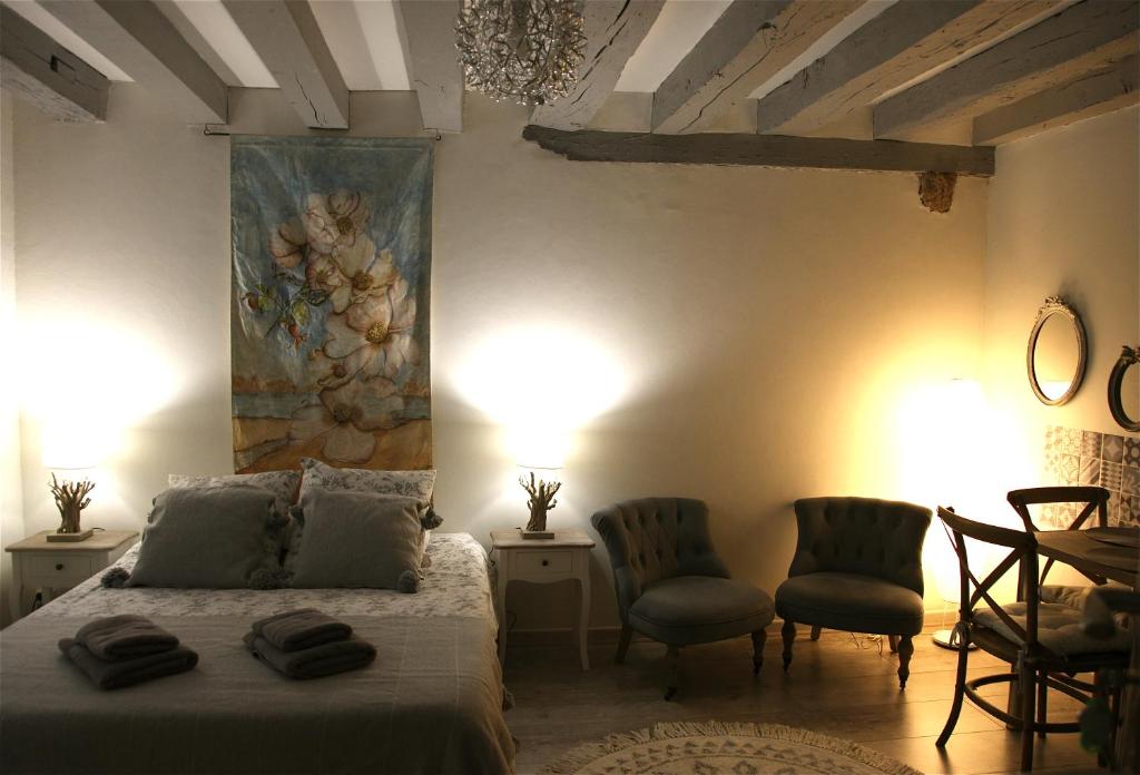 - une chambre avec un lit et deux chaises ainsi qu'une peinture murale dans l'établissement Chez Bruno et Françoise, à Blois