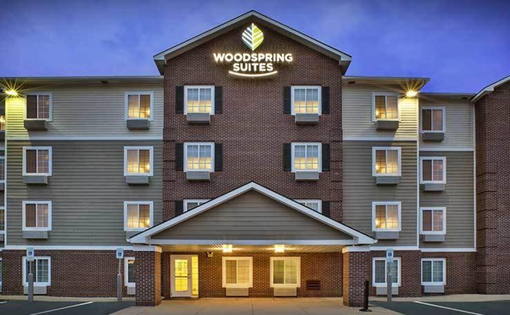 a building with a woodworking suite sign on it at WoodSpring Suites Holland - Grand Rapids in Holland