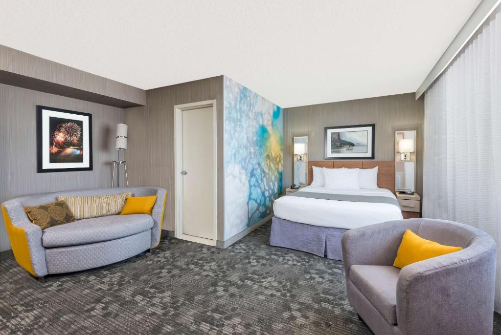 um quarto de hotel com uma cama e duas cadeiras em Wyndham Garden at Niagara Falls em Niagara Falls