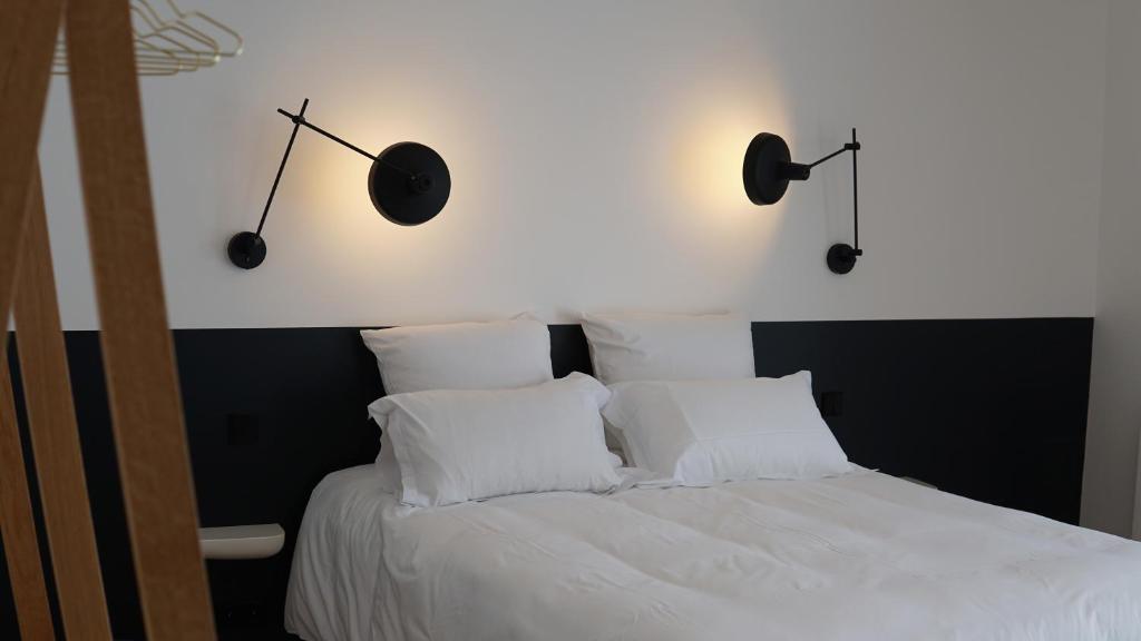 1 dormitorio con 1 cama con sábanas y almohadas blancas en Clos La Chapelle en Mareuil-sur-Ay