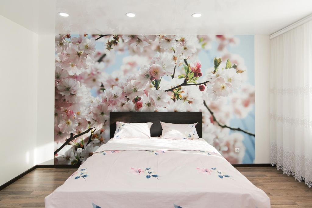 ein Schlafzimmer mit einem Bett mit Blumenwand in der Unterkunft 16 вулиця Прокоф'єва in Sumy