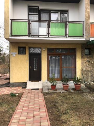 una casa con una puerta negra y macetas en Garabuczi Apartman, en Keszthely
