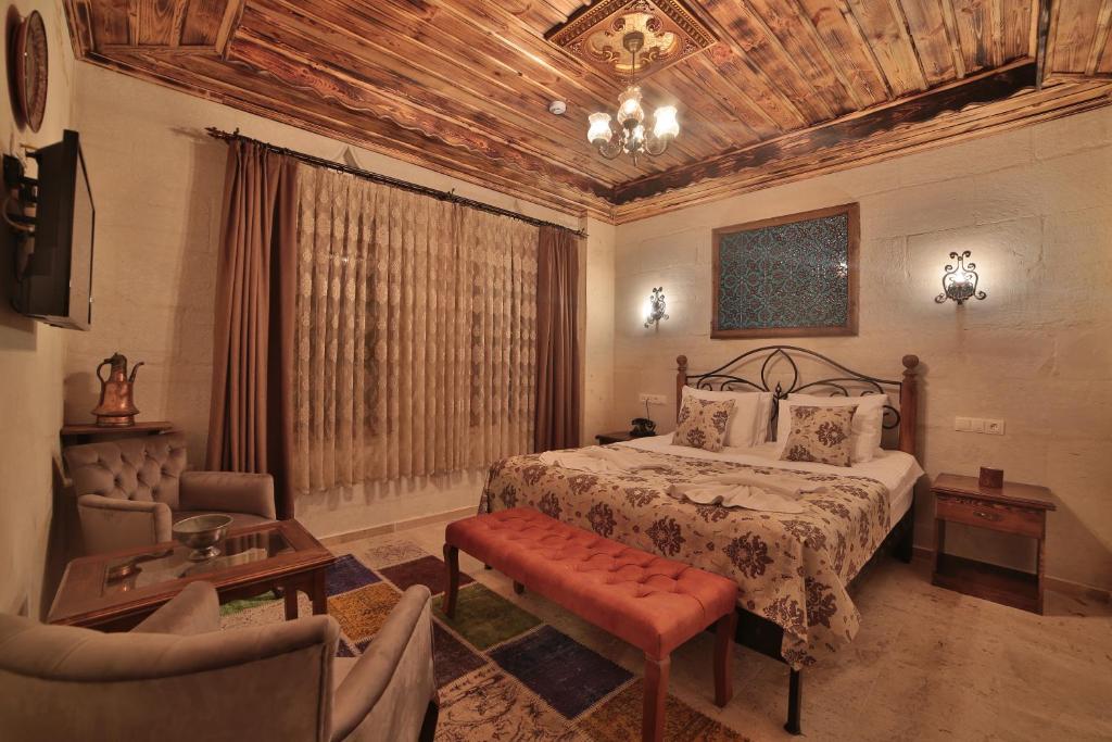 a bedroom with a bed and a couch and a chair at Caravanserai Inn Hotel in Goreme