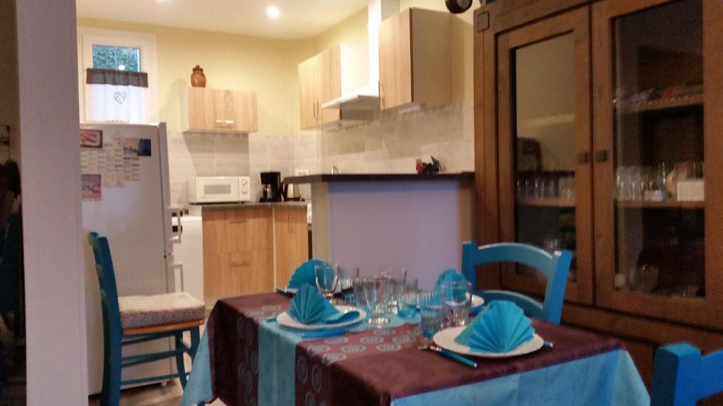 a kitchen with a table with a blue table cloth at LES BAIGNEUSES in Dieppe