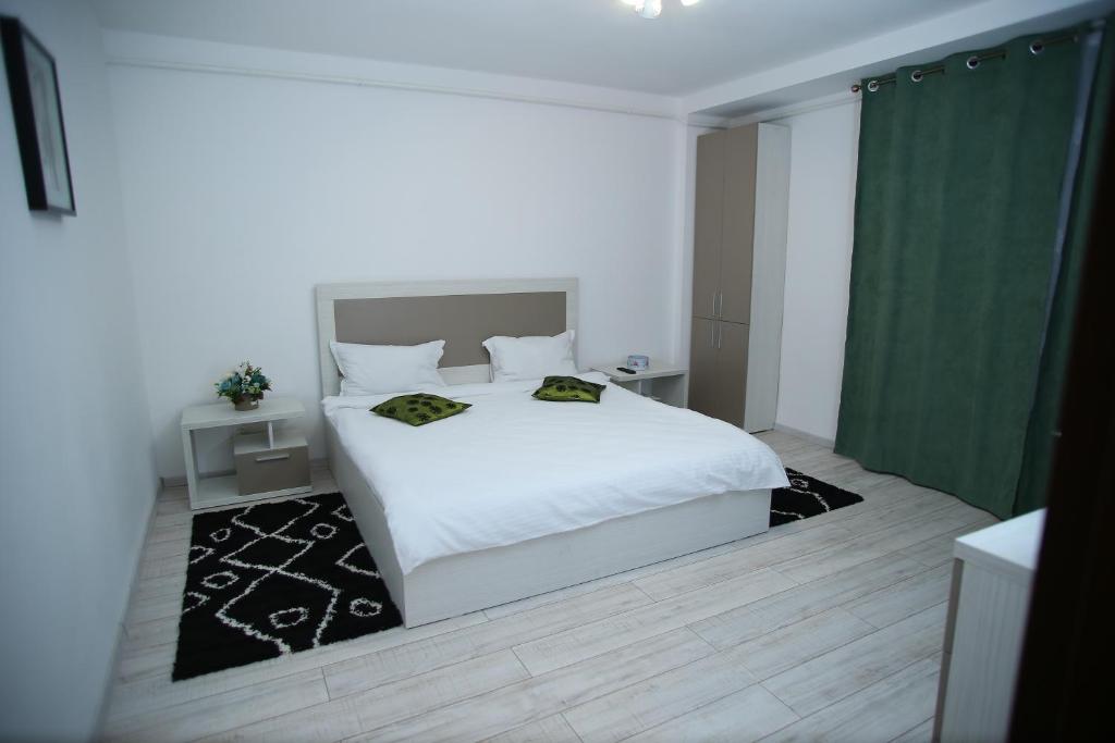 a bedroom with a white bed and a green curtain at RCC2 in Focşani