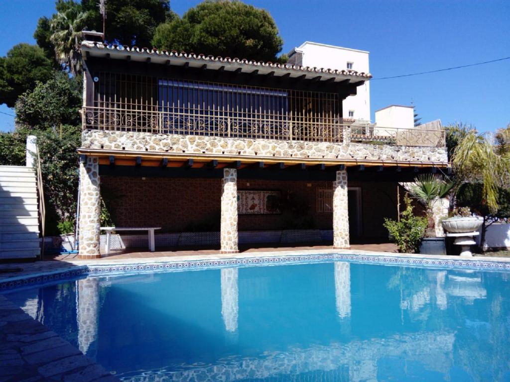 una casa con piscina frente a un edificio en Villa con piscina privada, en Torremolinos