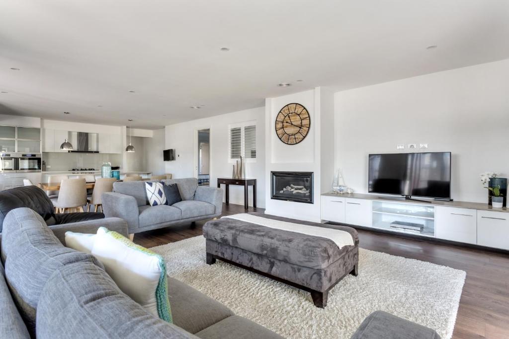 a living room with a couch and a tv at Luxury Capel Sound in Rye