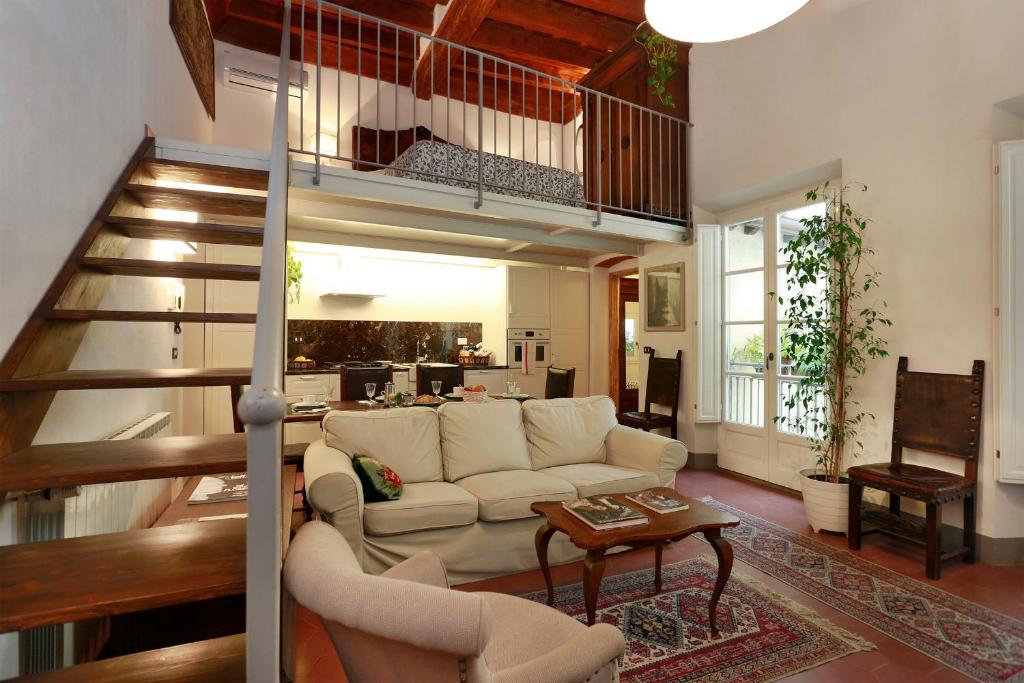 uma sala de estar com um sofá branco e uma escada em Florence Pitti Loft em Florença